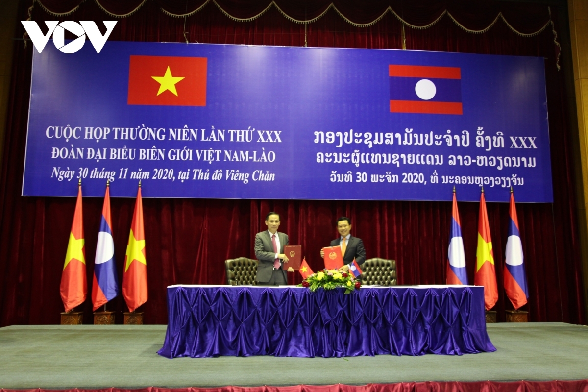  Deputy Minister Le Hoai Trung and Foreign Minister and Deputy Head of the Lao National Border Committee, Saleumxay Kommasith exchange minutes of cooperation on border management